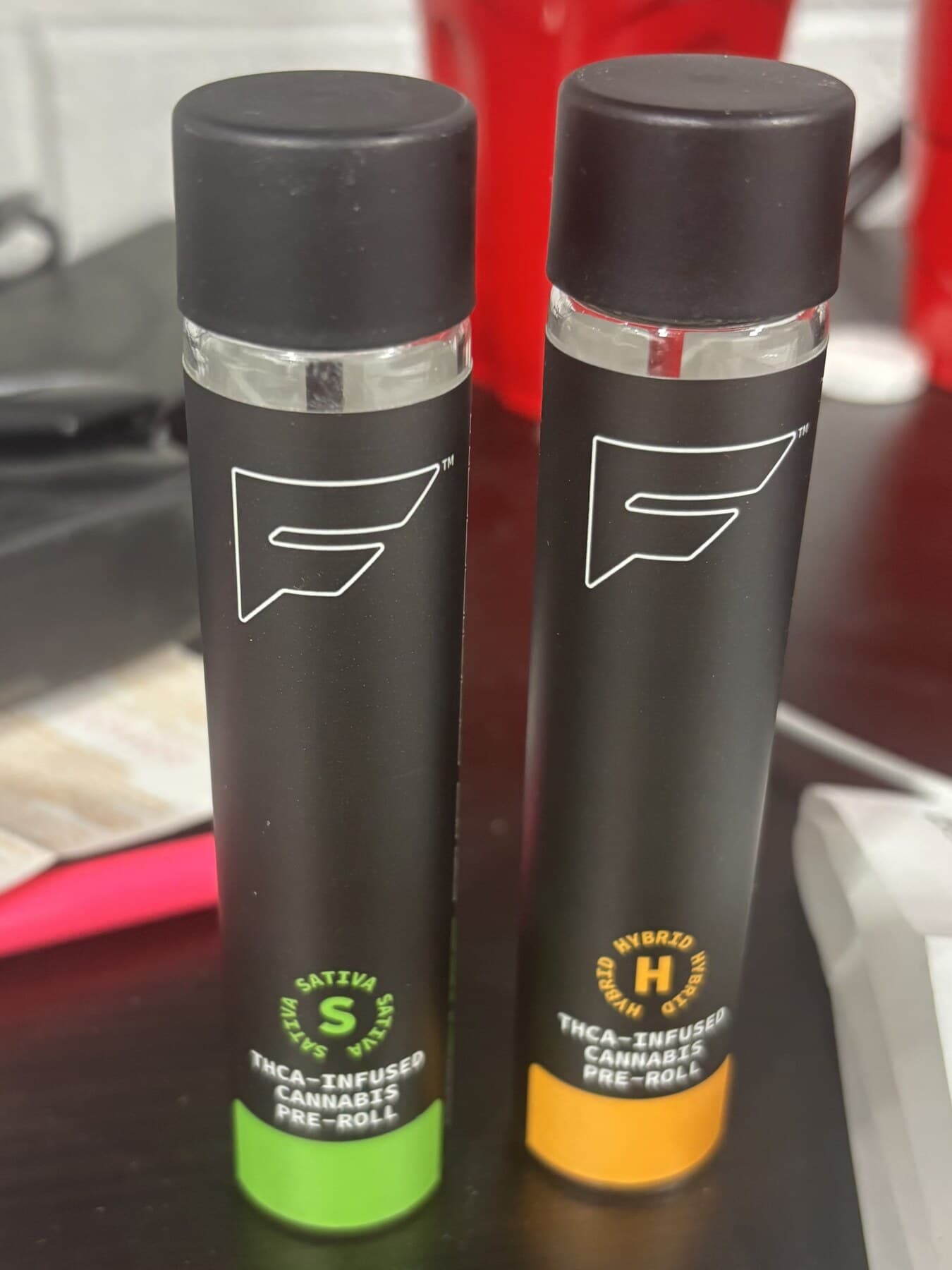 Child-resistant single-pre-roll tubes — compliance-labeled and strain-coded (Sativa / Hybrid) under the brand's own artwork. THCA-infused, packed and finished in-house.